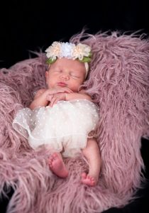 Photographer adjusting lighting and props for a newborn shoot